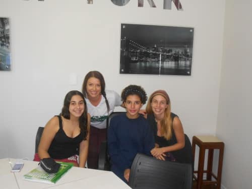 TTA alumna Rosie with three students in a classroom in Brazil