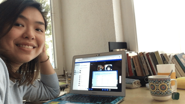 TTA alumni Lorraine smiling while at her desk during on online English lesson